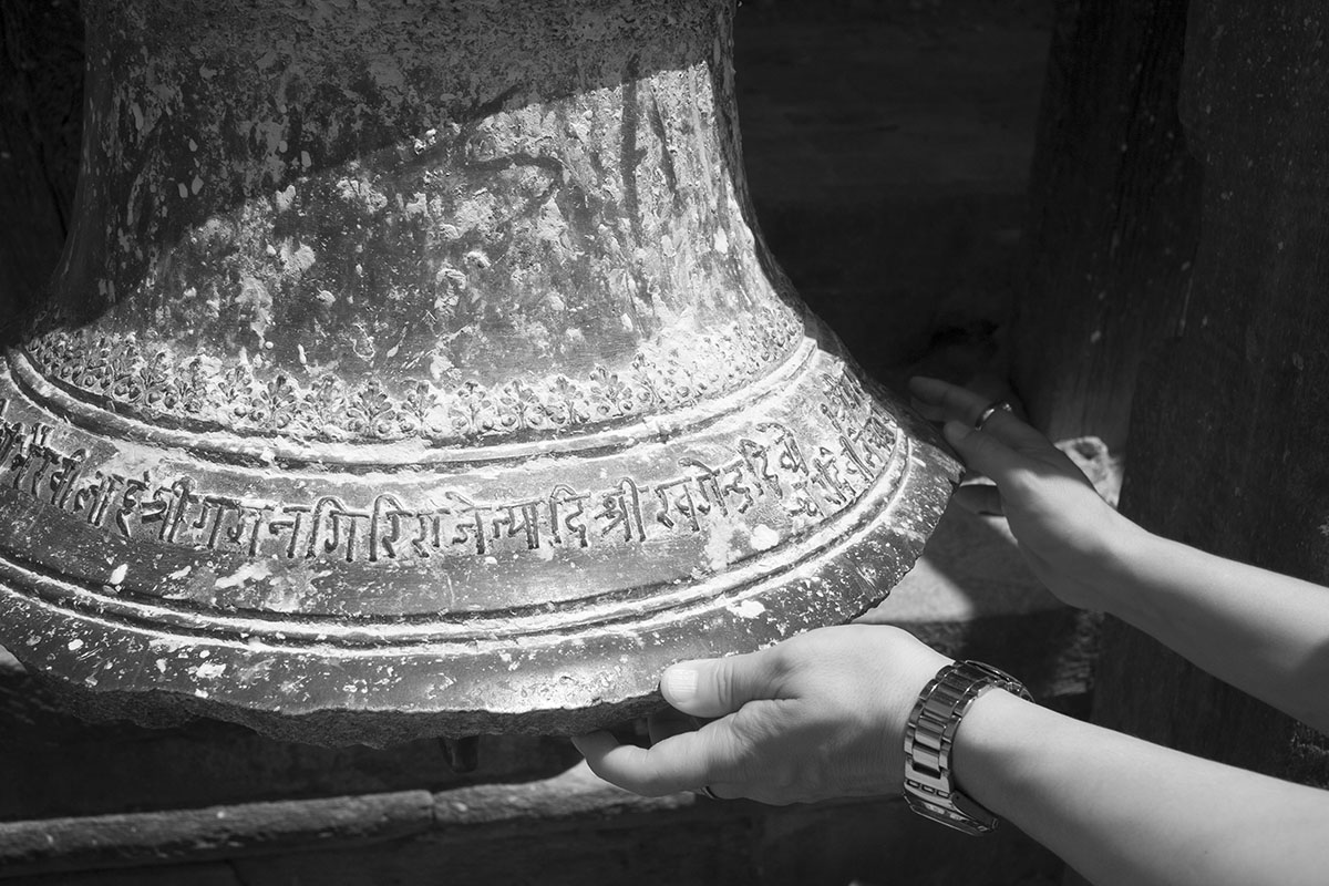 Big Newari Bronze Bell, Cradled by a Man's Hands.